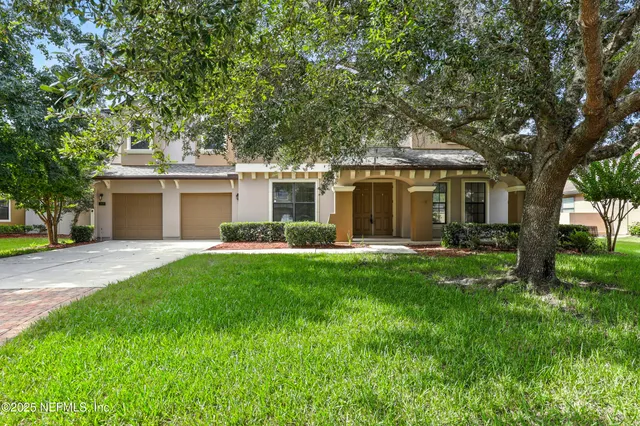a front view of a house with a yard and a garage