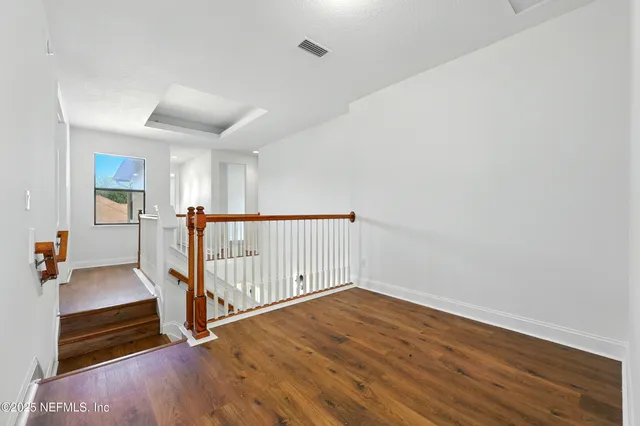a view of an empty room with windows and balcony