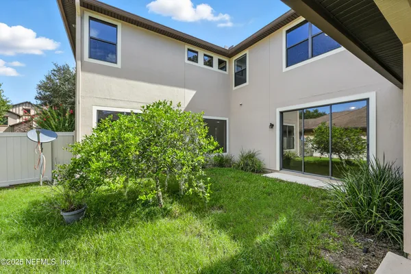 an aerial view of residential houses with outdoor space and trees all around