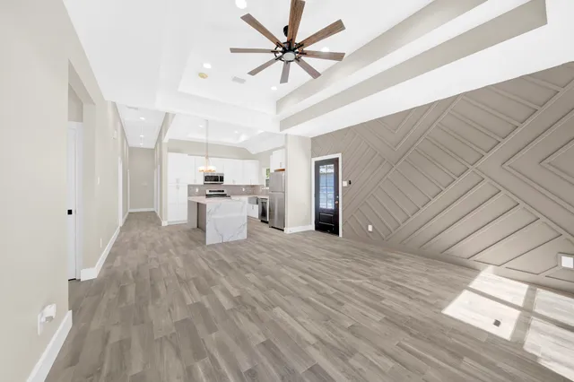 a view of a kitchen with a sink dishwasher microwave oven a refrigerator with wooden floor