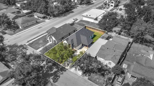 an aerial view of a house with a yard and a large tree