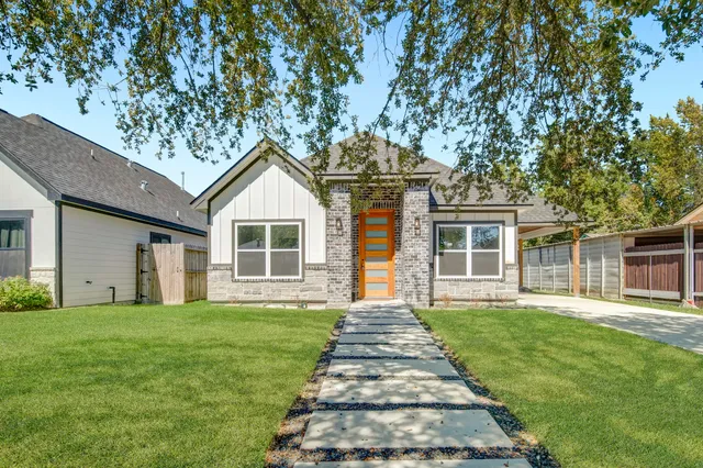 a front view of a house with a yard and trees