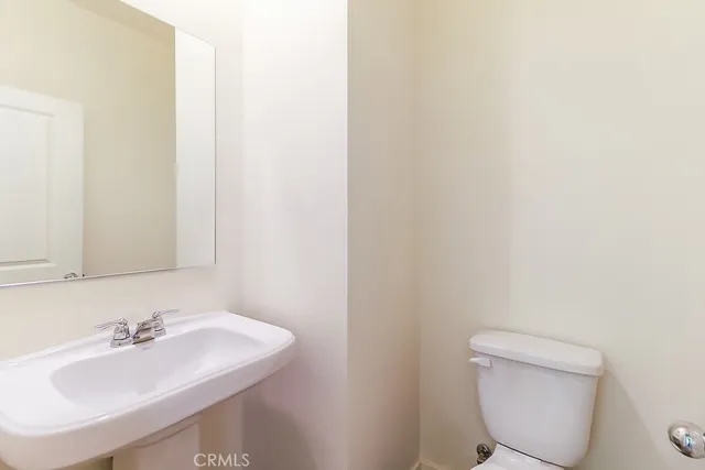 a bathroom with a sink a toilet and mirror