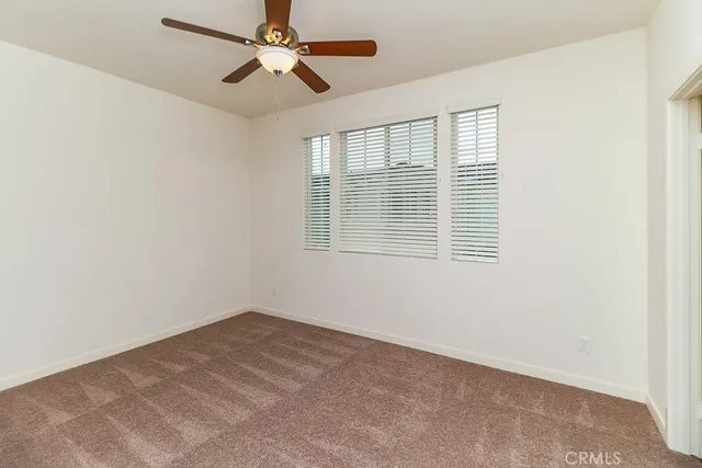 a view of a room with a ceiling fan and closet