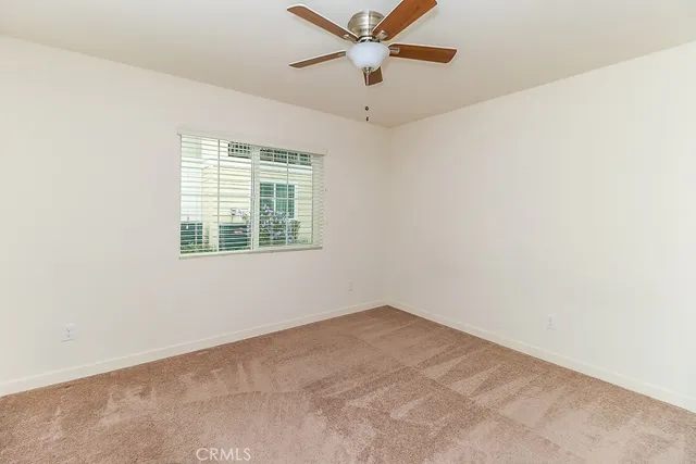 an empty room with a window and a fan