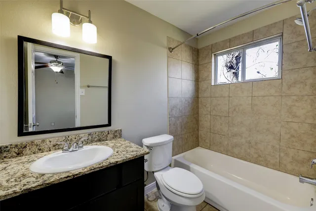 a bathroom with a granite countertop sink toilet and shower
