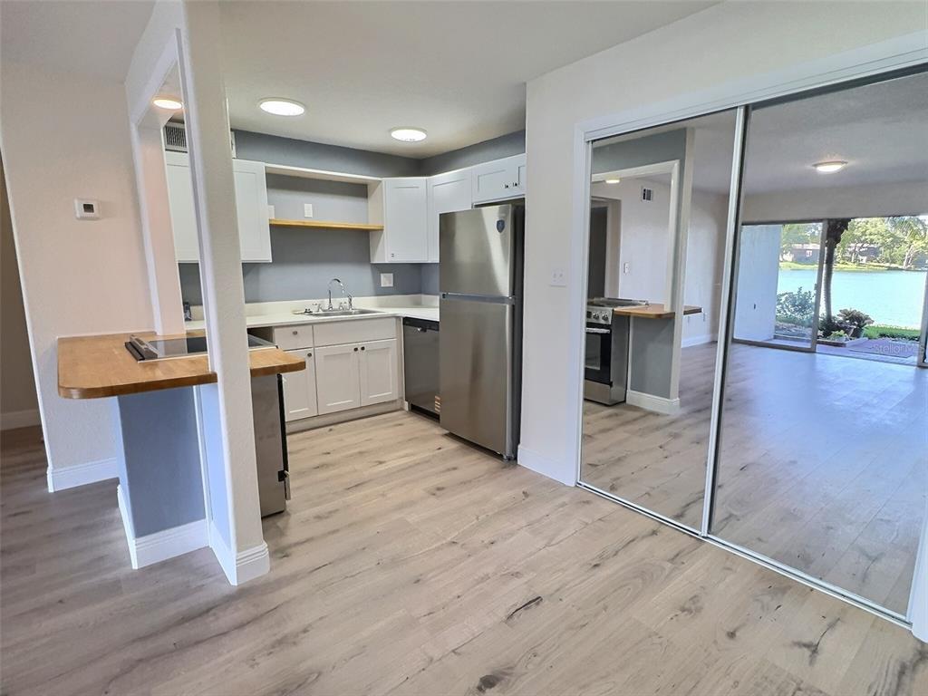 620 Orange Drive, Unit 225 Altamonte Springs, FL 32701 - Photo 4 of 25 a kitchen with a refrigerator a sink and cabinets