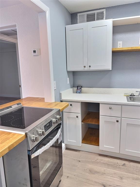 620 Orange Drive, Unit 225 Altamonte Springs, FL 32701 - Photo 6 of 25 a kitchen with a stove and white cabinets