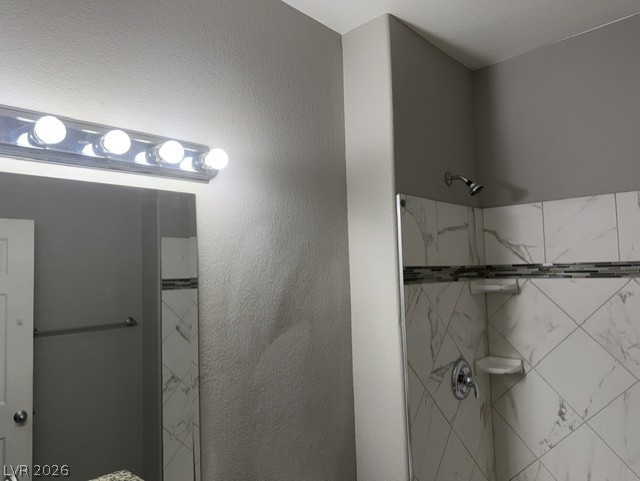 3318 North Decatur Boulevard, Unit 1163 Las Vegas, NV 89130 - Photo 34 of 35 Modern bath with bright vanity lighting and a chic tiled shower enclosure.