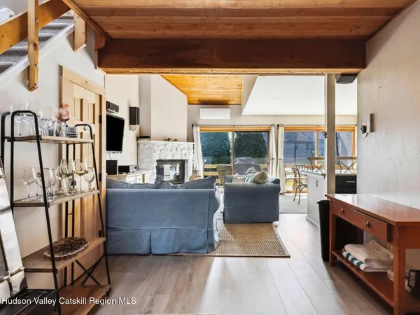 a living room with furniture a fireplace and a floor to ceiling window