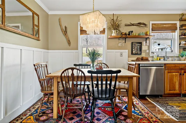a dining room with furniture a chandelier and wooden floor