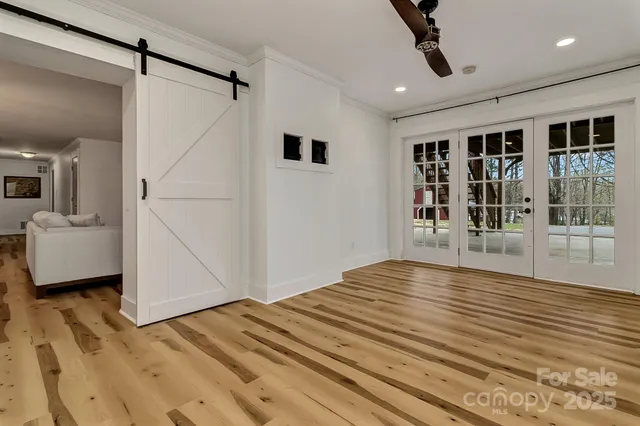 a view of a livingroom with wooden floor and a ceiling fan