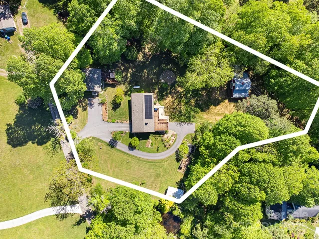 an aerial view of a house with a yard and large trees