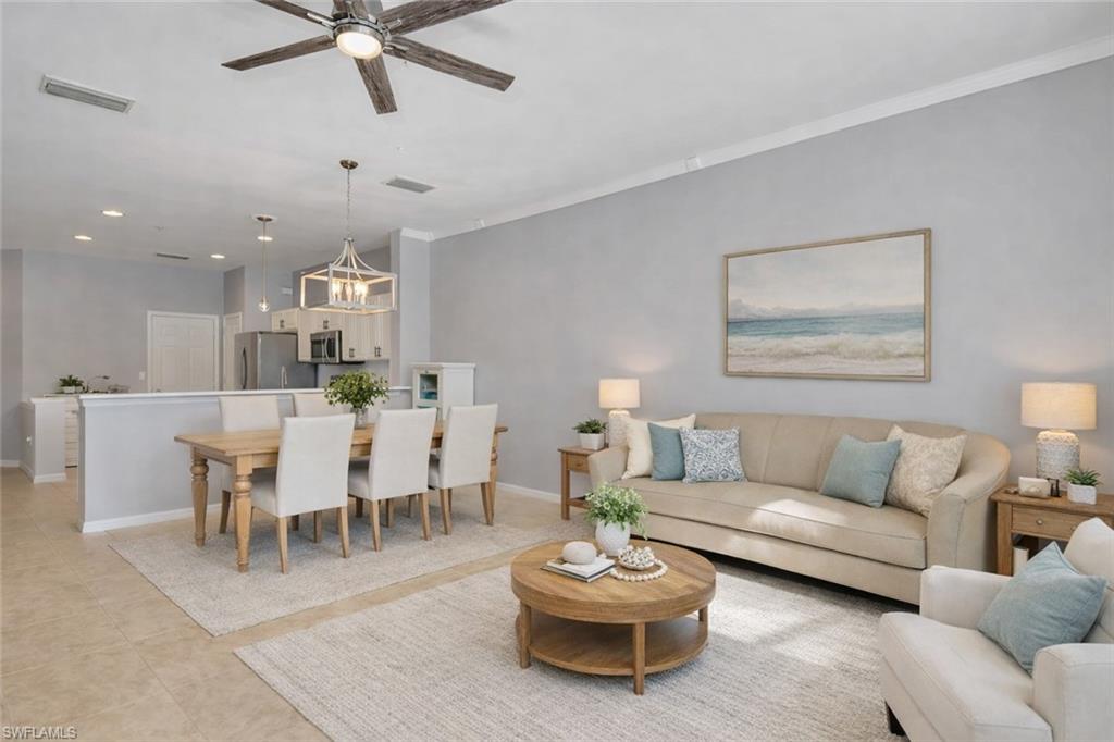 15918 Marcello Circle, Unit 239 Naples, FL 34110 - Photo 11 of 34 a living room with furniture a rug and a chandelier