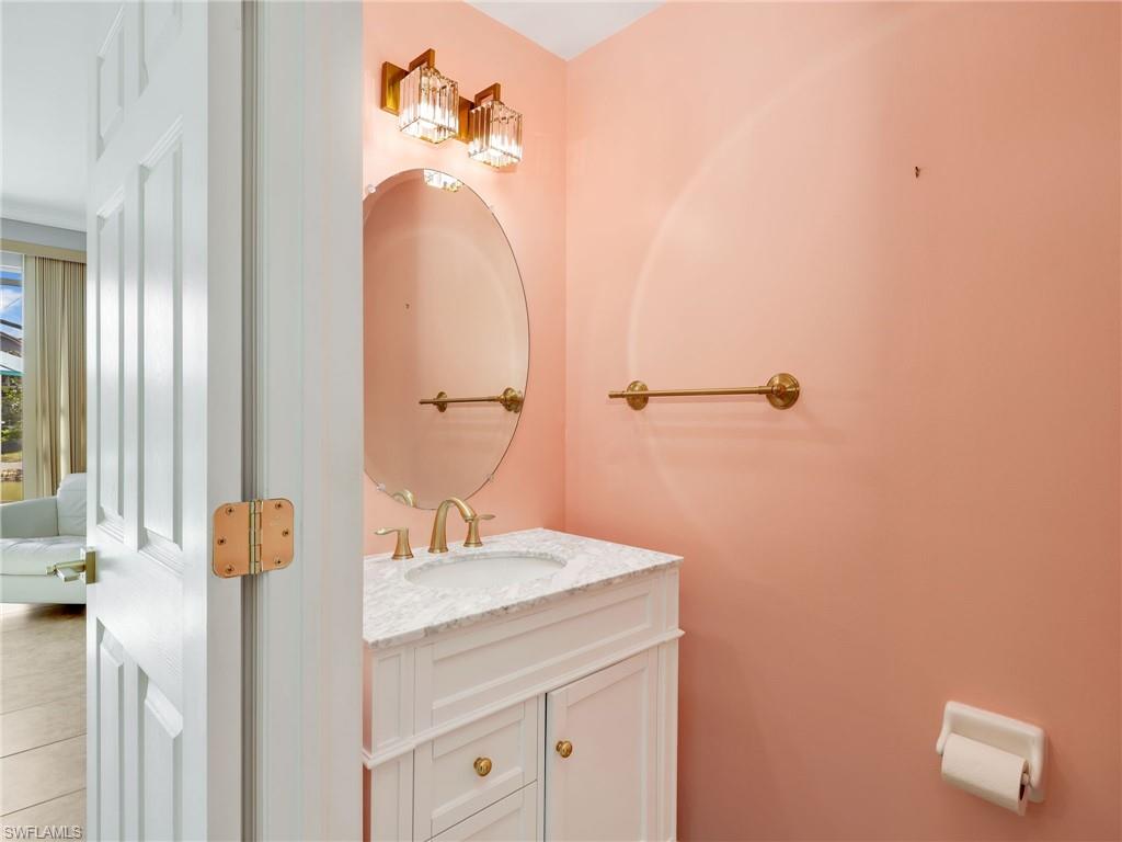 15918 Marcello Circle, Unit 239 Naples, FL 34110 - Photo 14 of 34 a bathroom with a sink and a mirror