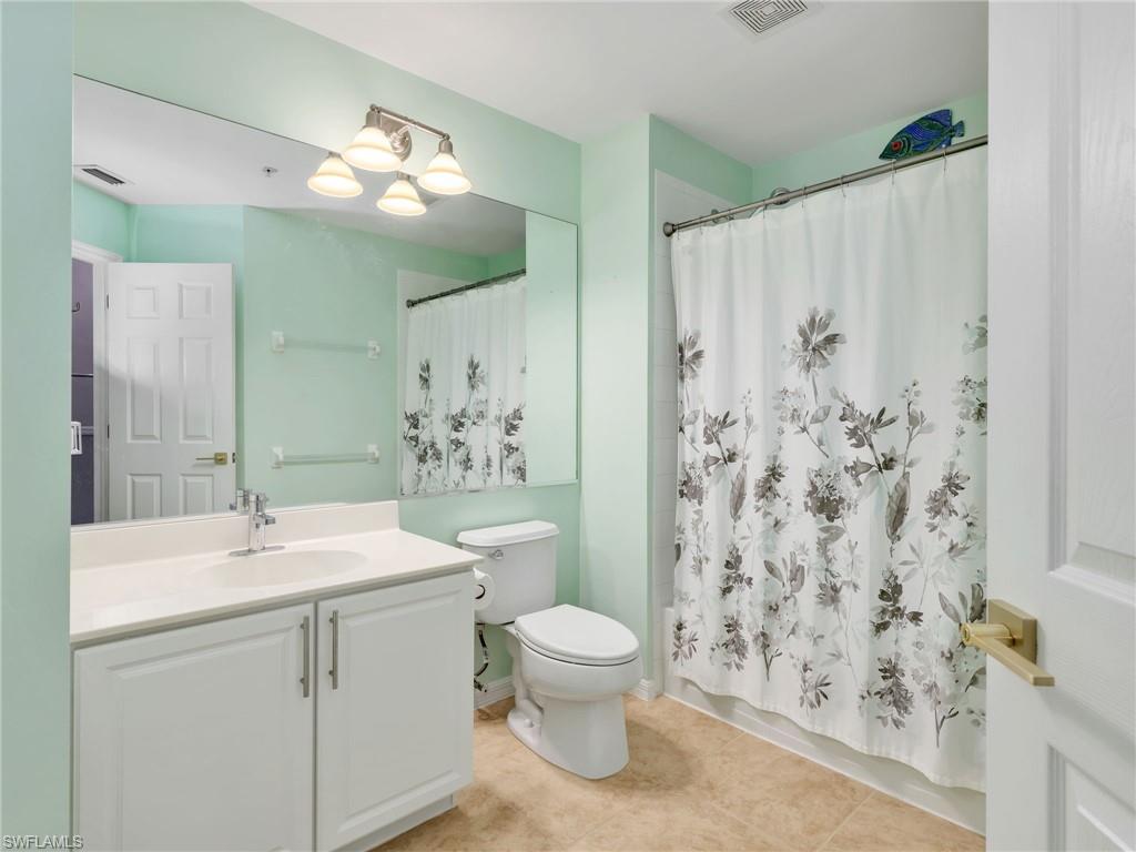 15918 Marcello Circle, Unit 239 Naples, FL 34110 - Photo 23 of 34 a bathroom with a sink a toilet and a mirror
