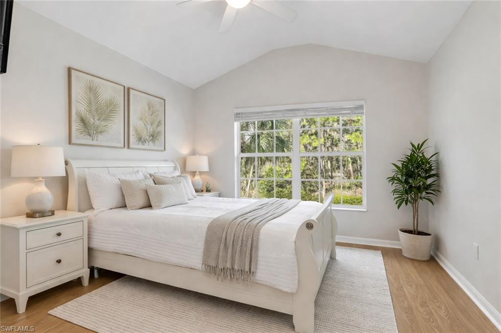 15918 Marcello Circle, Unit 239 Naples, FL 34110 - Photo 24 of 34 a bedroom with a large bed and a potted plant