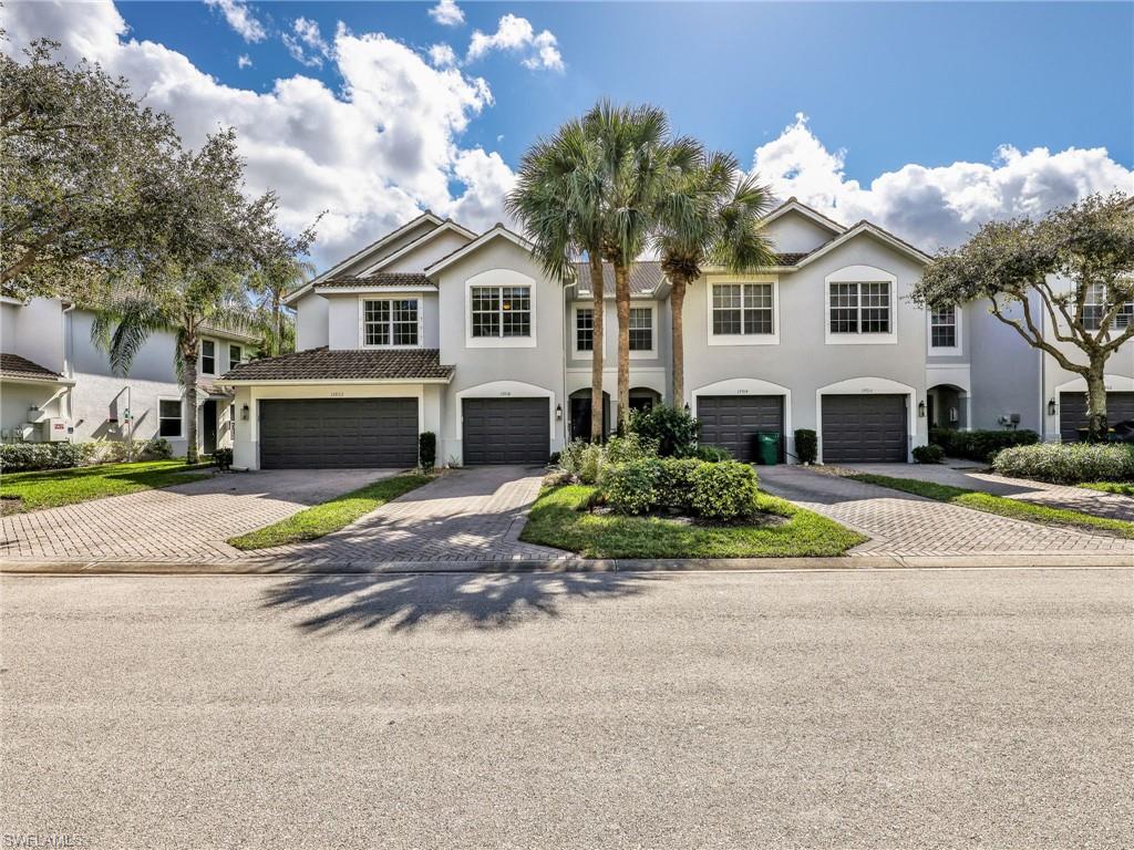 15918 Marcello Circle, Unit 239 Naples, FL 34110 - Photo 34 of 34 a front view of a house with a yard and garage
