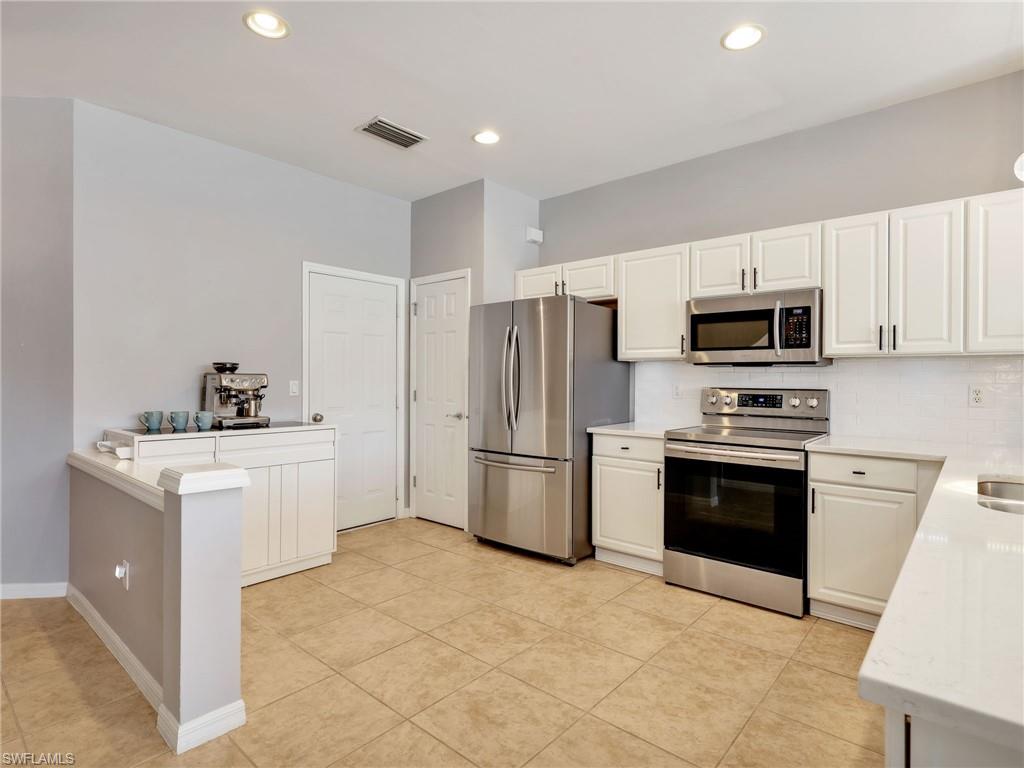 15918 Marcello Circle, Unit 239 Naples, FL 34110 - Photo 4 of 34 a kitchen with a sink stove and refrigerator