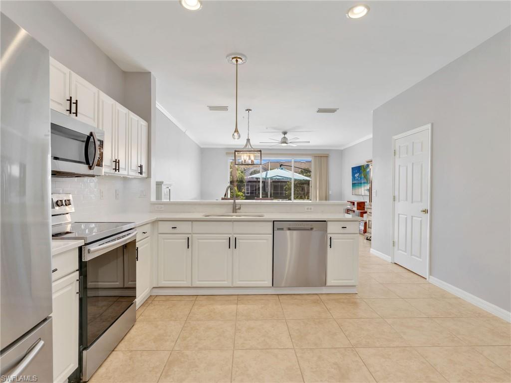 15918 Marcello Circle, Unit 239 Naples, FL 34110 - Photo 5 of 34 a kitchen with stainless steel appliances granite countertop a stove a sink and a refrigerator