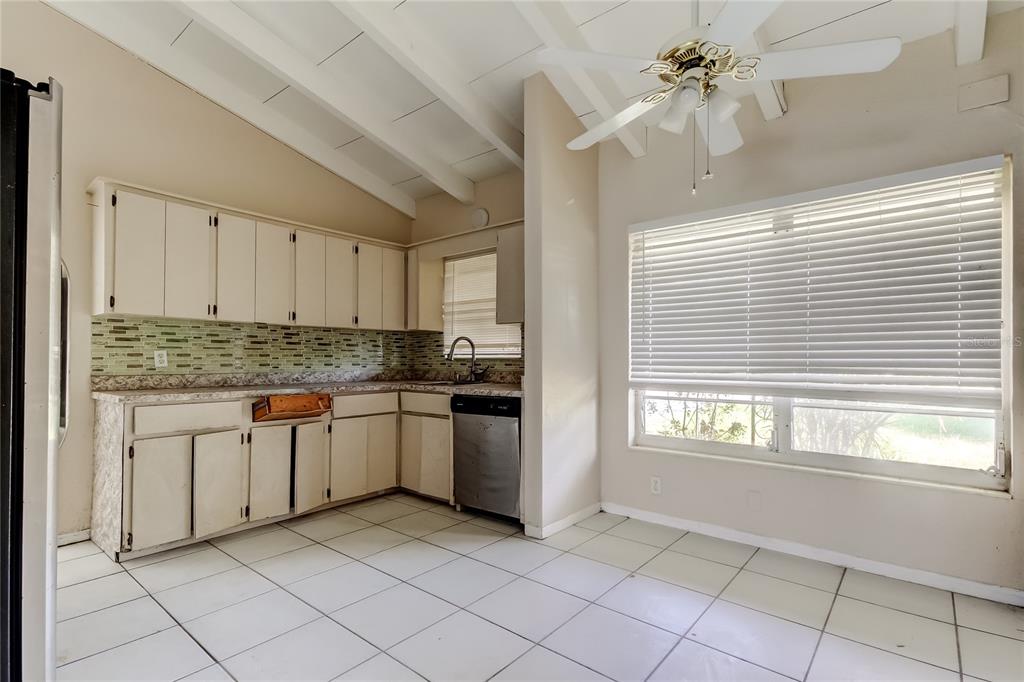 307 173rd Avenue North Redington Beach, FL 33708 - Photo 16 of 27 a kitchen with granite countertop a window and white cabinets