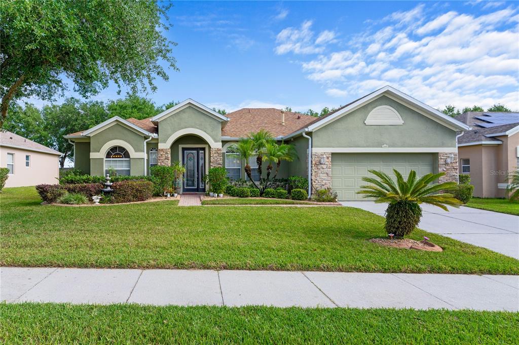 3440 Tumbling River Drive Clermont, FL 34711 - Photo 1 of 25 a front view of a house with a garden and yard