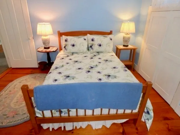 a bedroom with a bed and lamp on dresser