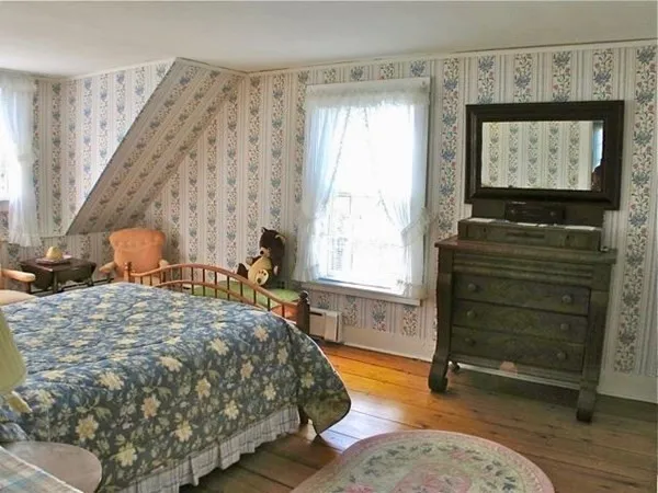 a bedroom with a bed and a flat tv screen on dresser