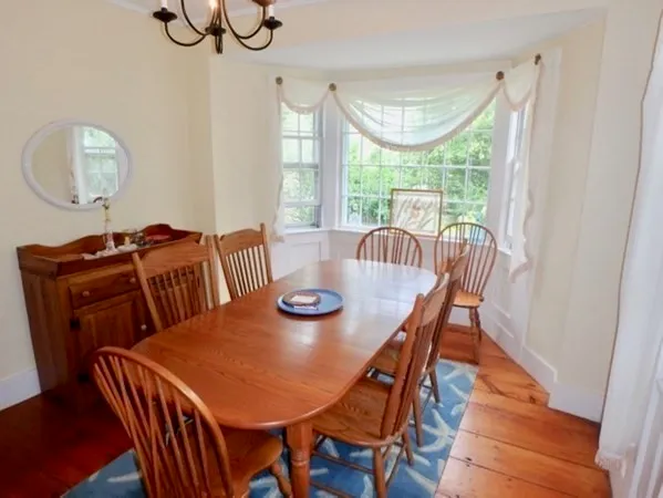 a view of a dining room with furniture a chandelier and wooden floor