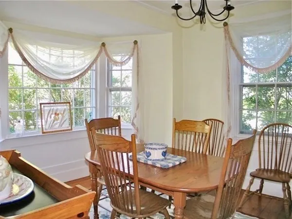 a view of a dining room with furniture a chandelier and wooden floor