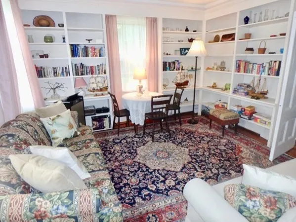 a living room with furniture and a book shelf