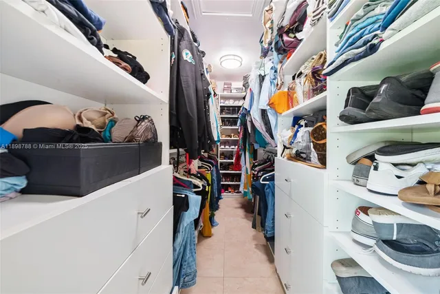 a view of walk in closet with clothes and shoes