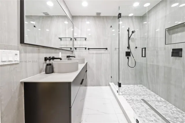 a bathroom with a sink a toilet a mirror and shower