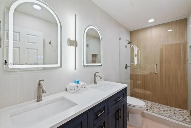 a bathroom with a double vanity sink toilet and shower