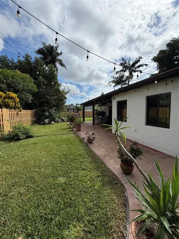 a backyard of a house with table and chairs