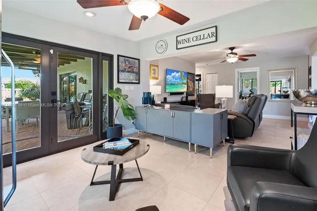 a living room with furniture a flat screen tv and a large window