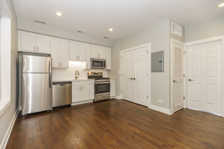 1915 West Irving Park Road, Unit 303 Chicago, IL 60613 - Photo 2 of 14 a kitchen with white cabinets and stainless steel appliances