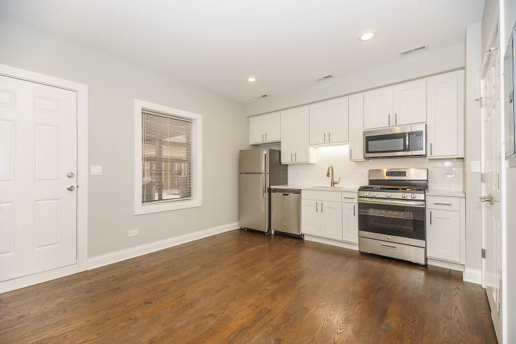 1915 West Irving Park Road, Unit 303 Chicago, IL 60613 - Photo 3 of 14 a kitchen with stainless steel appliances a refrigerator and a stove top oven