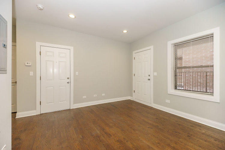 1915 West Irving Park Road, Unit 303 Chicago, IL 60613 - Photo 5 of 14 an empty room with wooden floor and windows