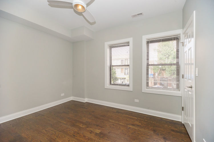 1915 West Irving Park Road, Unit 303 Chicago, IL 60613 - Photo 6 of 14 an empty room with wooden floor and windows