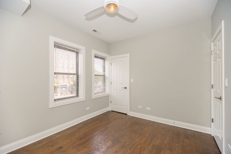 1915 West Irving Park Road, Unit 303 Chicago, IL 60613 - Photo 7 of 14 an empty room with wooden floor and windows