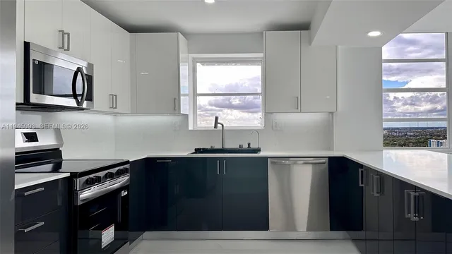 a kitchen with stainless steel appliances a sink dishwasher a stove and a refrigerator
