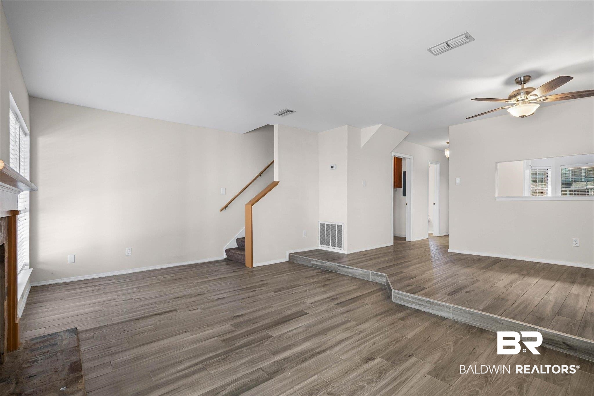 5900 Grelot Road, Unit 504 Mobile, AL 36609 - Photo 4 of 24 Unfurnished living room featuring a fireplace, ceiling fan, and wood finished floors