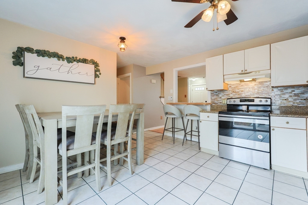 6 Erick Road, Unit 73 Mansfield, MA 02048 - Photo 8 of 21 a kitchen with stainless steel appliances kitchen island granite countertop a table chairs and a refrigerator
