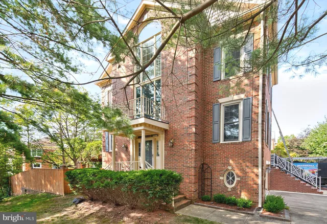 a view of a brick house with a large tree