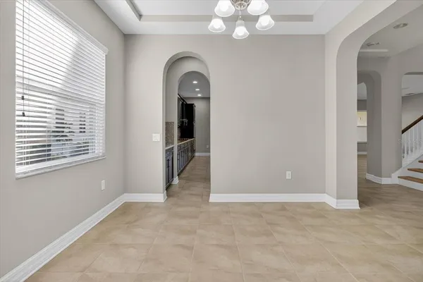 a kitchen with stainless steel appliances granite countertop wooden cabinets a dining table and chairs