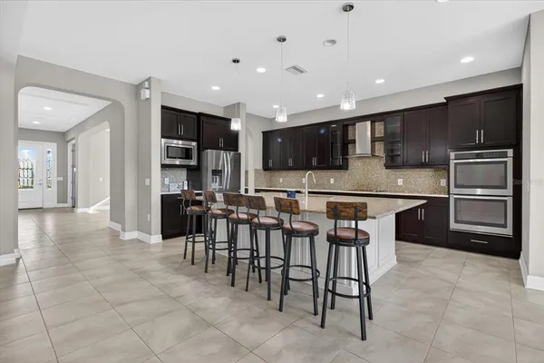 a kitchen with stainless steel appliances granite countertop a table and chairs in it
