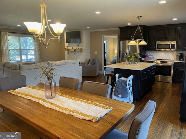 425 Trice Cemetery Road Thomaston, GA 30286 - Photo 6 of 30 a kitchen with kitchen island a stove a sink a dining table and chairs with wooden floor
