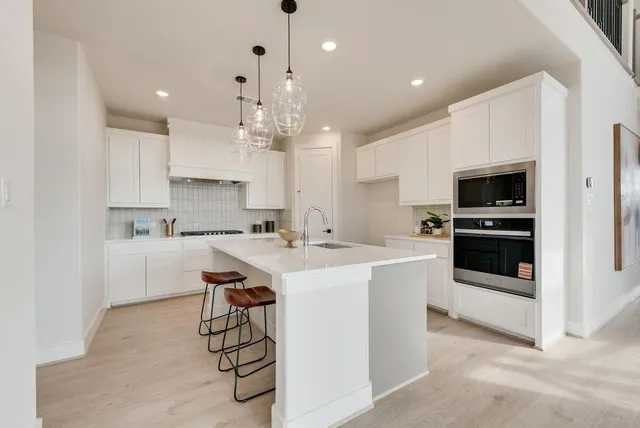 a kitchen with a sink stainless steel appliances and white cabinets