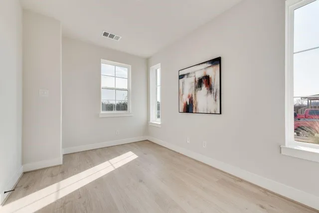 an empty room with windows and closet